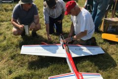 Three competitors discuss a  control line stunt model